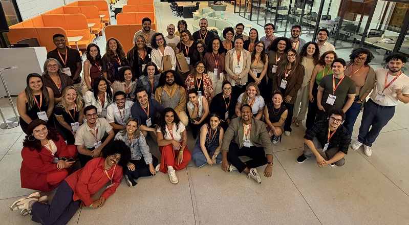 Participantes do evento "Lab Estratégia em Ação" reunidos para a foto geral. Todas as pessoas presentes na foto sorriem
